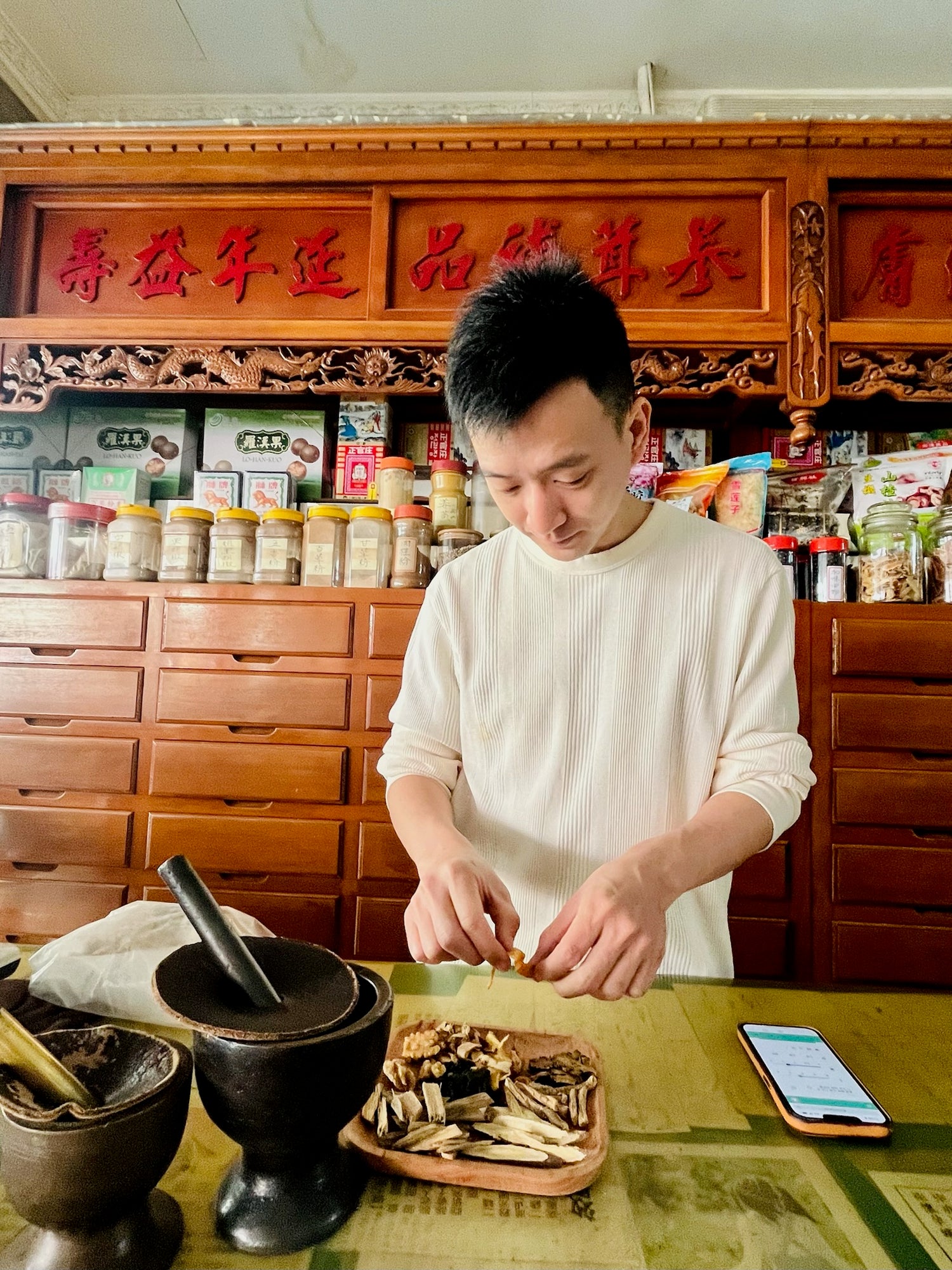 Founder of Mofa Cafe, Chun, working in the family TCM dispensary. 